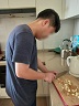 남자 훈련생이 도마에 마늘을 올리고 칼로 썰고있다.