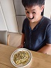 남자 훈련생이 완성되어 접시에 담긴 바질파스타르 보고있다.