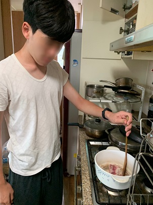 남자훈련생이 냄비에서 고기를 볶고있다.