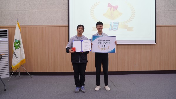 1등 수상자와 사무국장님이 상을 들고 있는 모습