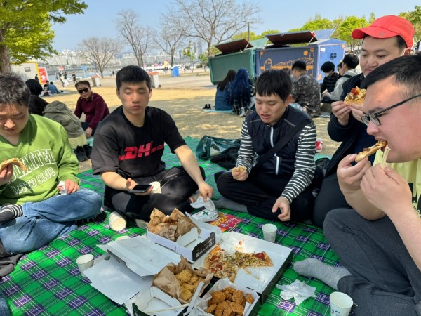 참여자들이 맛있게 간식(피자, 치킨)을 먹는 모습
