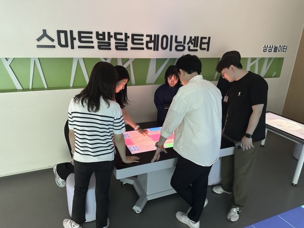 행복한우리복지관 담당자들이 터치테이블 기기를 체험하고 있다.