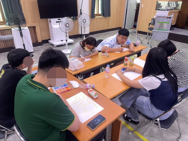 조별로 모여 참여자들이 도화지에 글, 그림을 그리고 있는 모습