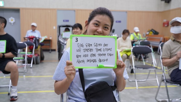 제2회 장애인권 바로 알기 퀴즈대회 1등 참여자가 화이트보드에 소감을 적어 들고 있는 모습