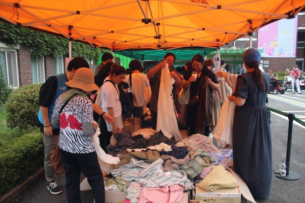 사람들이 바자회에서 물건을 고르고 있습니다.