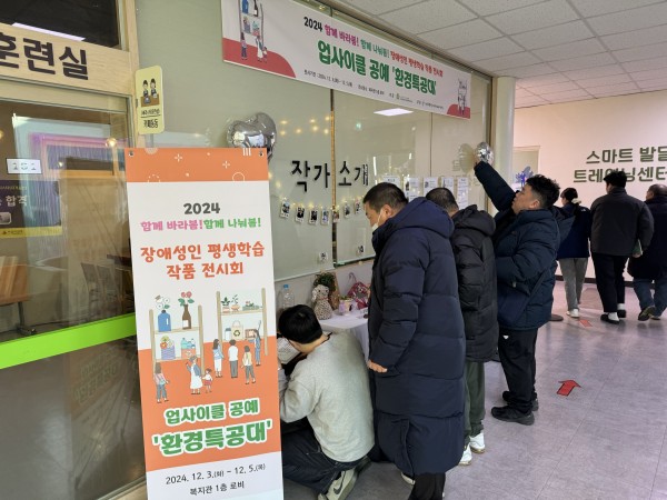전시회를 관람하는 사람들의 모습이 담긴 사진