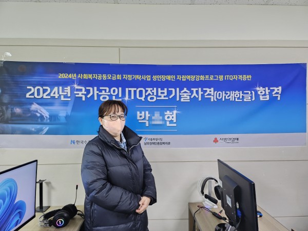 2024년 ITQ정보기술(아래한글) 자격증 합격자가 축하 현수막 앞에 서 있는 모습