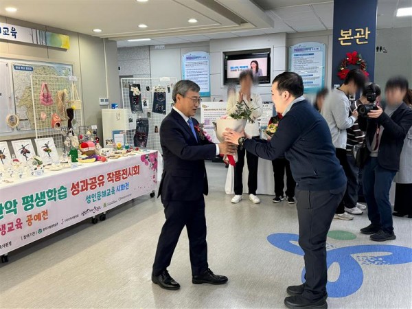 교육감님에게 꽃다발을 전달받고 있는 참여자의 사진