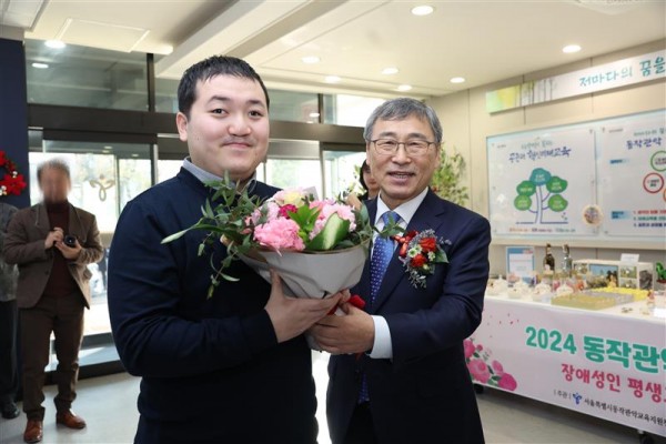 교육감님과 참여자가 꽃다발을 들고 함께 찍은 사진