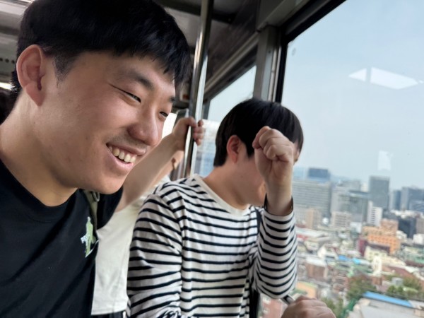 남산케이블카 안에서 바깥 풍경을 구경하고 있는 참여자와 미소를 짓고 있는 참여자 모습