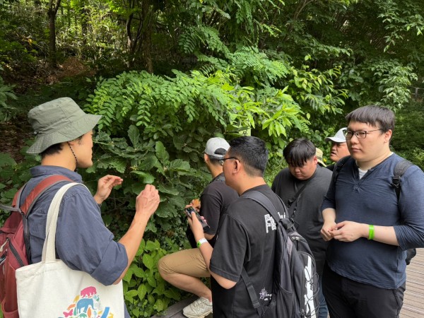 숲 해설가의 설명을 듣고 있는 사진