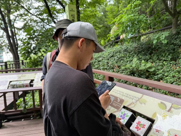 증강현실(AR)을 활용하여 스마트폰으로 식물을 보고 있는 사진