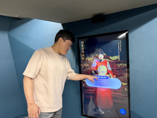터치스크린을 터치하며 세종대왕과 대화를 나누는 참여자 사진