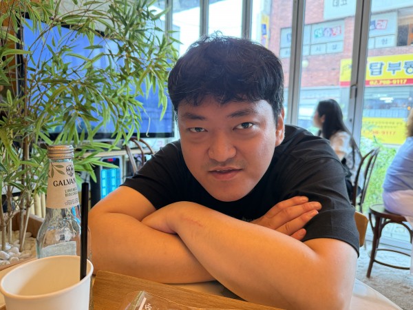 카페 의자에 앉아 미소를 띄고 있는 참여자 사진