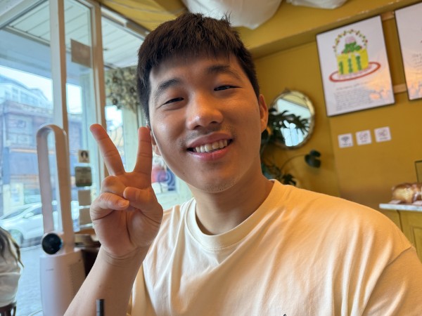 카페 의자에 앉아 웃으며 브이 포즈를 취한 참여자 사진