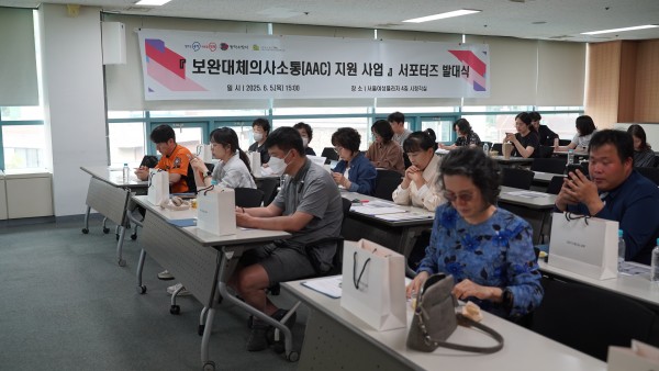 교육장에서 책상에 앉아 교육을 듣는 참여자들의 모습