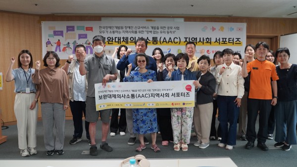화이팅을 하면서 현수막을 들고 단체사진을 찍고 있는 모습
