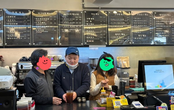 함께 만든 아이스 아메리카노를 전달하기 위해 &quot;주문하신 아이스 아메리카노 나왔습니다&quot;를 말하고 있는 참여자의 모습