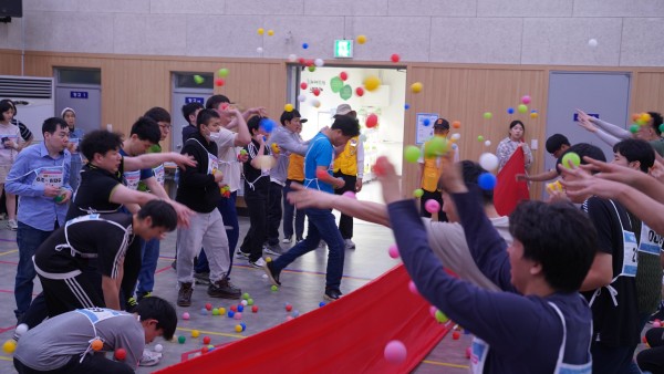 서울시립남부장애인종합복지관 강당에서 중앙에 빨간 천을 놓고 양 옆으로 고무 공을 던지는 사진