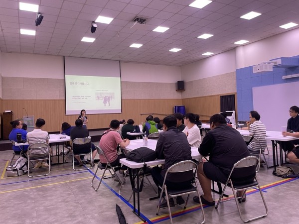 복지관 강당에서 취업자 간담회 참여자들이 테이블에 앉아 인권교육을 듣고있는 사진
