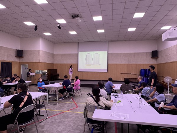 복지관 강당에서 참여자 인권교육을 강사가 진행하고, 책상에 앉아 이를 집중해서 듣고 있는 참여자들의 뒷모습