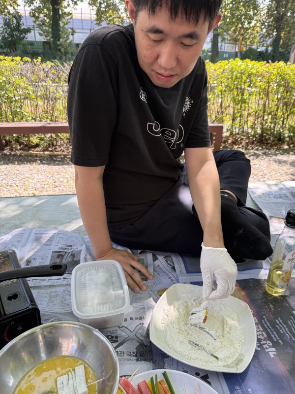 꼬치전을 부침가루에 묻히는 모습
