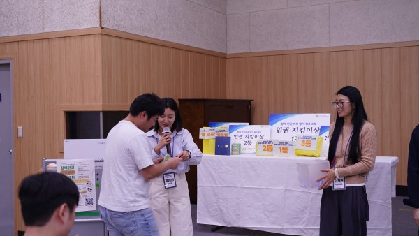 행운권 추첨에서 당첨된 참여자가 선물을 받고 있는 모습