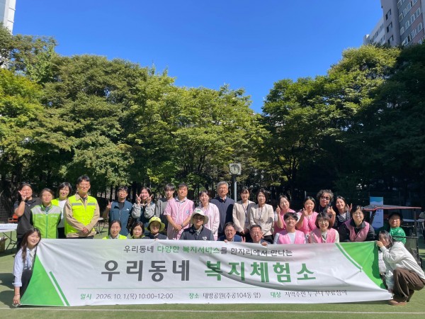 행사를 진행한 직원들이 현수막을 들고 사진을 찍고 있습니다.