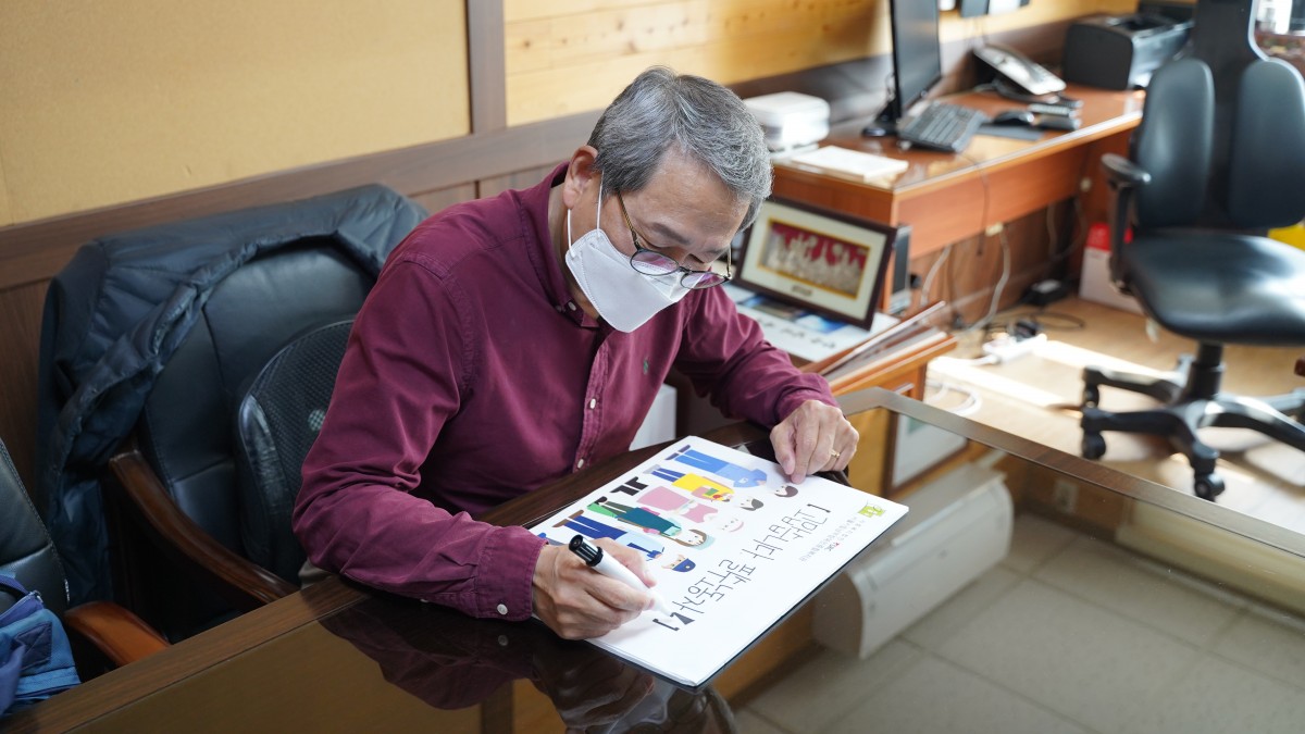 고맙습니다 필수노동자 캠페인 문구를 쓰고 있는 장순욱 관장님의 모습