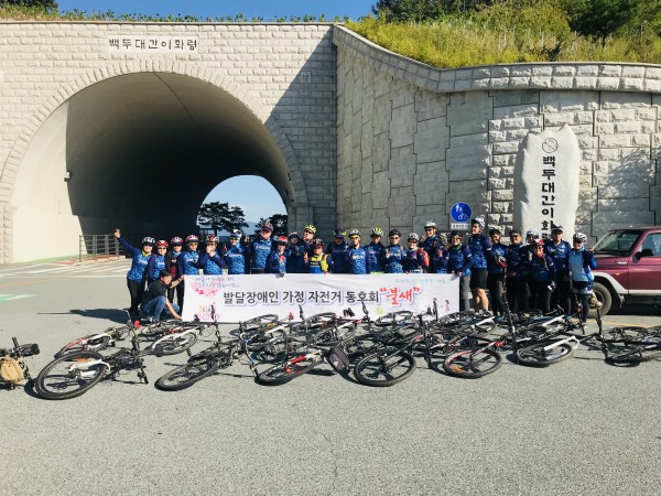 불새 동아리 회원들이 이화령고개 정상에서 단체 사진을 찍는 모습 