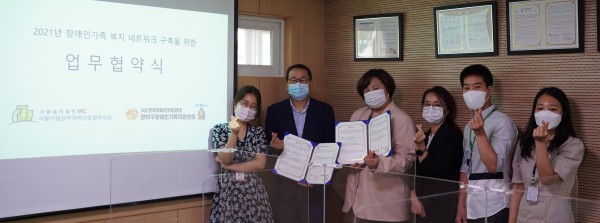 오른쪽부터 가족지원상담팀 팀장, 서울시립남부장애인종합복지관 관장, 관악구장애인가족지원센터장, 서울시립남부장애인종합복지관 사무국장, 관악구장애인가족지원센터 팀장, 가족지원상담팀 거점복지관 담당자 순으로 서 있으며, 손 하트를 하고 있다.