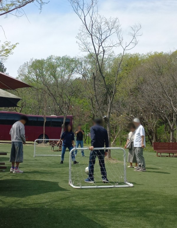 여성 담당직원과 발달장애인 남성 3명이 함께 축구공을 서로에게 패스하는 모습이다.